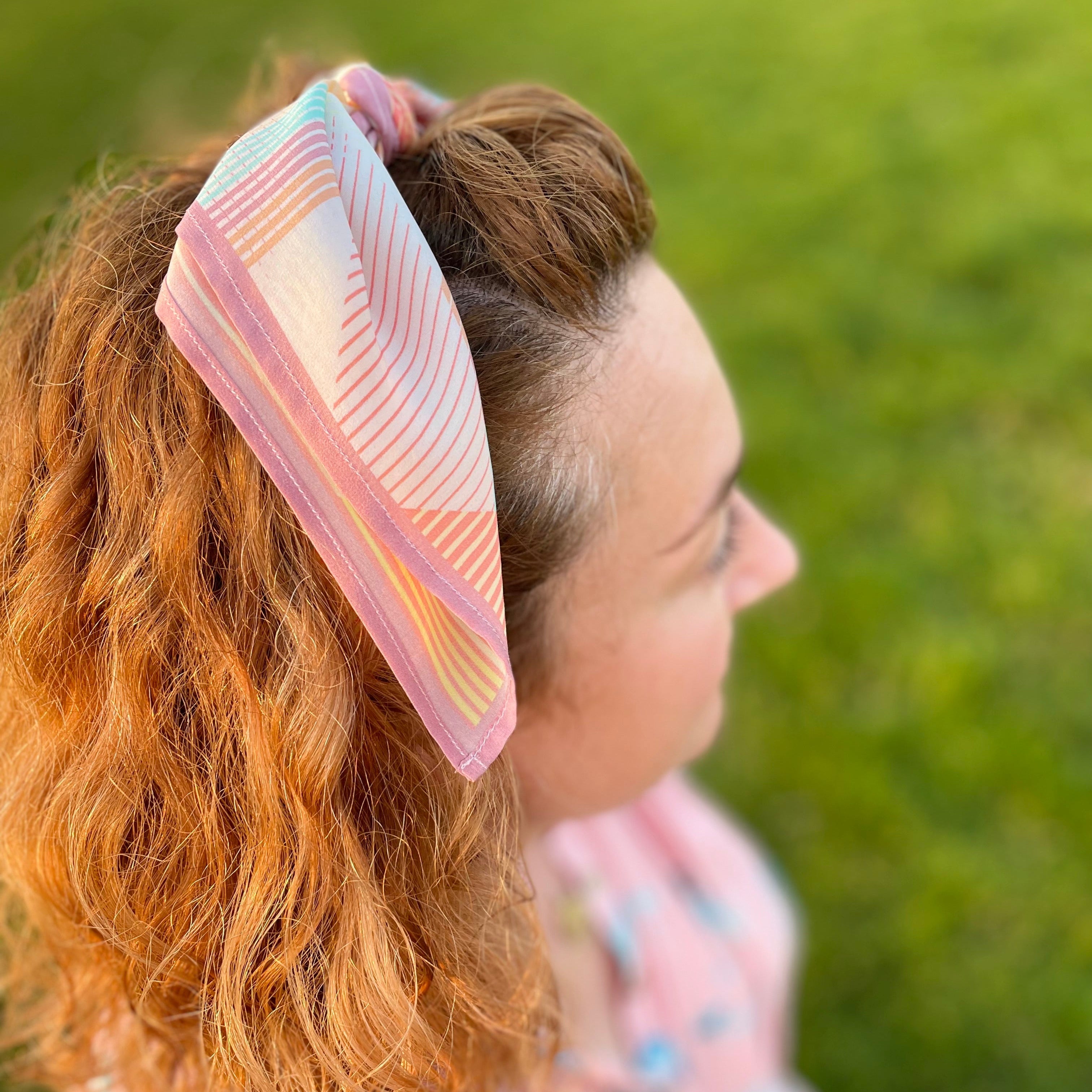 Person with a colorful headband against a grassy background